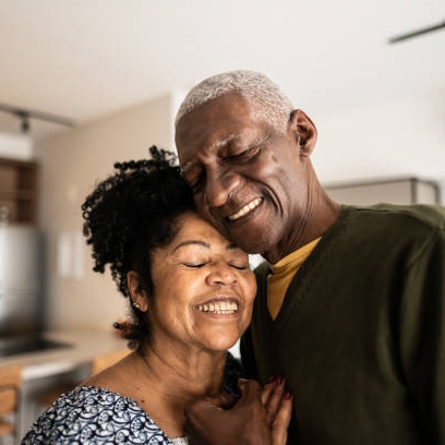 Senior couple embracing each other at home